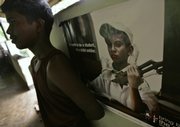 A former Sri Lankan child soldier leans against a wall with a poster showing a child soldier Oct. 1 in a classroom at a government rehabilitation center in the village of Ambepussa, about 40 miles northeast of capital Colombo, Sri Lanka. About 570 children are among an estimated 10,000 former rebels sent to rehabilitation centers after the 25-year war for a separate Tamil state ended in May.