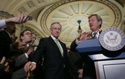 Senate Finance Committee Chairman Sen. Max Baucus, D-Mont., right, answers a reporter’s question Tuesday on Capitol Hill in Washington as Senate Majority Leader Harry Reid, D-Nev., center, listens.