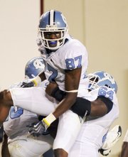 North Carolina’s Jheranie Boyd (87) celebrates his touchdown with teammate Jonathan Cooper. The Tar Heels defeated Virginia Tech, 20-17, on Thursday night in Blacksburg, Va.