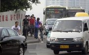 Chinese cyclists navigate on a narrow sidewalk Oct. 13 in Guangzhou in southern China. Throngs of cyclists are an iconic image for China, but they are having a harder time on the roads as a swelling middle class switches to cars.