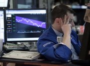 Specialist Michael Bonanno works at his post on the floor of the New York Stock Exchange on Friday. The Dow Jones industrial average plunged nearly 250 points on concerns about weak consumer spending and stagnant wages.