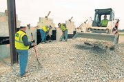 Kenny Mooney, left, watches while Matthew Kuticka and Bob Williams finish shoveling and Justin Hannah, right, moves a load of rock last week at the construction site of an overpass for U.S. Highway 71 south of Lamar, Mo. The employees of JLA Construction, Republic, Mo, said they have been off work for periods of 2009 and don’t have prospects for more work after this job is completed in a couple of weeks.