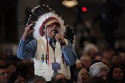 Wearing a traditional headdress, Marcus Levings, chairman of the Three Affiliated Tribes, gestures as he asks President Barack Obama a question Thursday during the White House Tribal Nations Conference, which took place at the Interior Department in Washington.