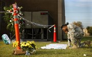 Sgt. 1st Class Noval Alexander pauses to read some of the condolences at a makeshift memorial Saturday at Fort Hood, Texas.