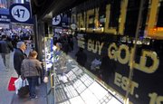 Shoppers browse store windows Wednesday on 47th Street in New York’s diamond district, where gold is bought and sold. The price of gold set a new record Wednesday of $1,119 an ounce.