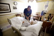Joe Takach, in this Oct. 30 photo, talks to his friend Lillian Landry as she spends her last days in the hospice wing of an Oakland Park, Fla., hospital. She made her end-of-life decisions on how she wanted to die and to be buried. Democrats in the U.S. House are trying to nudge more Americans to make their end-of-life decisions.