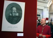 Monsignor Gianfranco Ravasi looks on near a portrait of Italian astronomer Galileo Galilei, part of the “Galilei Divin Uomo” (Galilei Divine Man) exhibit, in the Santa Maria degli Angeli Basilica in Rome in this Feb. 15, 2009, file photo.