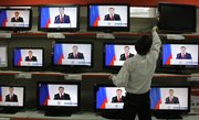A vendor adjusts a display with TV sets broadcasting Russian President Dmitry Medvedev’s address to the nation at a Moscow shop on Thursday. In his speech, Medvedev suggested condensing the number of time zones across the 5,500-mile wide country from 11 to four.