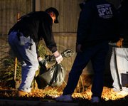 Officers from the Society for the Prevention of Cruelty to Animals unearth animal remains Saturday in the backyard of Sharon McDonough’s Selden, N.Y. home. Authorities are trying to determine whether any of the 20 dead dogs found buried in her backyard might have been pets stolen from neighbors.