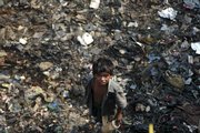Vijay, a street child, stands on a pile of garbage Wednesday in Dharavi, Asia’s largest slum, in Mumbai, India. Twenty years after the U.N. adopted a treaty guaranteeing children’s rights, fewer youngsters are dying and more are going to school, but an estimated 1 billion still lack services essential to their survival and development, UNICEF said Thursday.