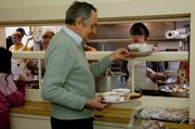Ronald Shewchuk gets a plate for himself and his wife, Helen, on Wednesday at the Loaves and Fishes soup kitchen in Ithaca, N.Y. The Shewchuks have been eating many of their meals at the soup kitchen since losing most of their retirement savings during the economic downturn.
