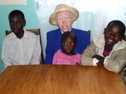 Mary Owido, who lacks pigment that gives color to skin, eyes and hair, sits with her children Steven, left, Stella, and Brayan, Tuesday at their home in the western Kenyan town of Ahero. Albino body parts are believed to have magical powers, and thousands of Africa’s albinos are afraid of losing their lives and limbs to dealers who can make up to $75,000 selling a complete dismembered set.