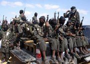 Armed fighters from Somalia’s al-Shabab jihadist movement travel on the back of pickup trucks outside Mogadishu in this Dec. 8, 2008, file photo. Training camps in the lawless nation of Somalia are attracting hundreds of foreigners, including Americans, and Somalis recruited by a local insurgent group linked to al-Qaida, according to local and U.S. officials.