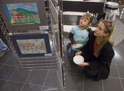 Heather McLeod and her daughter Jadelin look over some of the artwork by Sunset Hill School students featured at Meritrust Credit Union, 4821 W. Sixth St. There was an opening exhibition at the credit union Dec. 1.