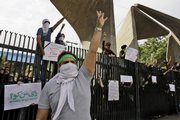Students hold banners in an elections protest June 15 at the gate of Tehran University in Tehran. Iranian students are besieged by a clampdown in the universities, with a wave of arrests and expulsions as they gear up for a major anti-government protest Monday.