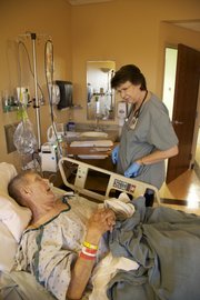Judy Schwinn, a registered nurse at Lawrence Memorial Hospital, suffered a hip fracture about four years ago. She also suffers from osteoporosis. Last week, she was checking on patient Donald Cope, 76, of Tulsa, Okla. He was getting ready for surgery on a broken femur.