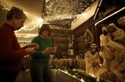 Chris Jump and Connie Hadl, left, both of Lawrence, set up the newest addition to Jump's Nativity collection as part of the Festival of Nativities on Saturday, Dec. 12, 2009, at the Centenary United Methodist Church. Jump said this set, from the headwaters of the Amazon, depicts the holy family as Shipido people.