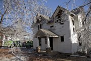 Trees are covered in ice around the house at the southeast corner of 17th and Tennessee that was destroyed in a fire Monday night.