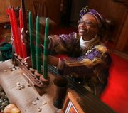 Ruth Ndiagne Dorsey sets up for Kwanzaa Dec. 8 at her church, The Shrine of the Black Madonna, in Atlanta. African-Americans’ opinions of Kwanzaa vary, from saying it connects them to their ancestors to believing it racist.