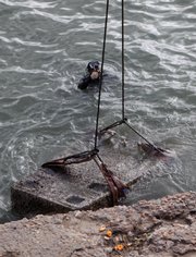 A sunken red granite tower, part of a pylon of the Isis temple, is lifted Thursday out of the Mediterranean Sea off the archaeological eastern harbor of Alexandria, Egypt.