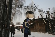 Tourists walk under a newly installed copy of the inscription “Arbeit Macht Frei” on Friday at the main entrance to the former Nazi death camp Auschwitz Birkenau, in Oswiecim, southern Poland. The original infamous iron sign over the main entrance to the former Nazi death camp Auschwitz Birkenau was stolen before dawn Friday and the police launched an intensive search.