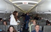 Stranded passengers aboard JetBlue Flight 751 to Cancun walk around the cabin while waiting hours to take off at John F. Kennedy International Airport in New York in this Feb. 14, 2007, file photo. The Obama administration Monday ordered airlines to let passengers disembark after three hours in the event of stranded airplanes.