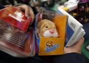 A shopper waits in a checkout line with a Zhu Zhu Pet hamster and other items Nov. 27 at the Toys “R” Us in Camp Hill, Pa. Those who haven’t gotten their hands on Zhu Zhu pets yet may have to wait until after Christmas.