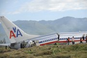 Workers and police investigators sift through debris surrounding the cracked fuselage of American Airlines flight AA331, which crash landed overnight Wednesday on a flight from Miami to Jamaica, just beyond the runway of Norman Manley International Airport in Kingston. More than 40 people were injured, at least 4 seriously, and there were no fatalities, according to officials, after the plane overshot the runway when it landed in heavy rain.
