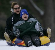 Lawrence resident Marissa Brumley and her son, K.J. Brumley, 11, cruise down Campanile Hill at Kansas University. The mother and son, like other area residents, experienced the fun side of the recent snowfall on Dec. 30, 2009.