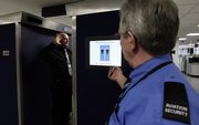 Staff members demonstrate a new full body security scanner Thursday at Manchester Airport in England. European Union countries are not all agreed on whether to use the scanners.