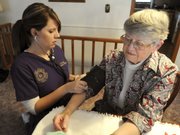 Tyffani Post, a student nurse at Kansas Wesleyan University, takes the blood pressure of Marilyn Ericson in this Dec. 23, 2009, photo in Salina. More than a dozen nurses in Salina have been serving members of a church congregation as a parish nurse.