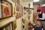 Joshua Anderson, parish council president of St. Sophia Orthodox Church in Lawrence, participates in communion during service Sunday, Jan. 10, 2010. Icons line the wall at left. In Orthodox Christianity, icons are sacred works of art that provide inspiration and connect the worshiper with the spiritual world. The scenes depicted in icons usually relate to liturgical celebrations rather than directly to historical events.