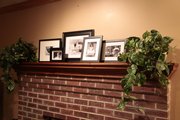 The mantel is re-decorated after the holidays with a simple collection of framed photos in black and white.