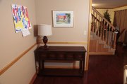 Laura Tiffany moves a hallway table, top, to a new location behind a couch to add display and storage space.