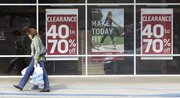 With purchases in hand, a shopper walks past a store advertising clearance sales Thursday in Tallahassee, Fla. Retail sales unexpectedly fell in December, leaving 2009 with the biggest yearly drop on record and highlighting the formidable hurdles facing the economy as it struggles to recover from the deepest recession in seven decades.