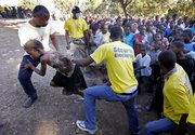 A girl is helped up a hill when it’s her turn to receive food at a distribution site run by the U.S. Army 82nd Airborne Division a week after the massive earthquake in Port-au-Prince, Haiti.
