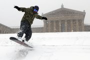 Mike Nagao snowboards down the snow-covered steps of the Philadelphia Museum of Art during a winter storm Saturday in Philadelphia.