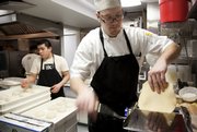 Executive chef Michael Beard lowers dough into a slicer as he and staff members prepare various kinds of homemade noodles at 715.
