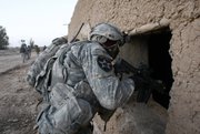 A U.S. soldier of the 1st Battalion, 17th Infantry Regiment, 5th Brigade, 2nd Infantry Division, looks into a building ‘s window during a dismounted patrol Friday in the Badula Qulp area, west of Lashkar Gah in Helmand province, southern Afghanistan.