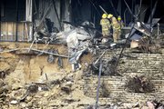 Firefighters get a close look at the damaged remains of a small aircraft, left, Friday inside a building in Austin, Texas. Joseph Stack flew his small airplane Thursday into the building that houses several offices of the Internal Revenue Service.