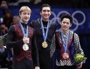 Gold medalist Evan Lysacek of the USA, center, silver medalist Evgeni Plushenko of Russia, left, and bronze medalist Daisuke Takahashi of Japan, right, pose on the podium during the medal ceremony for the men’s figure skating competition Thursday at the Vancouver 2010 Olympics in Vancouver, British Columbia.