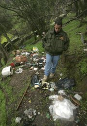 Fresno County Sheriff’s Lt. Rick Ko walks through a campsite at an abandoned marijuana growing site in the Sequoia National Forest near Fresno, Calif.