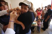 A boy squirms as he is vaccinated Friday in Constitucion, Chile. An 8.8-magnitude earthquake struck central Chile last Saturday, causing widespread damage and prompting concerns about disease outbreaks..