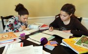 Louisa Perry-Farr, 13, left, works on science while her 10-year-old sister Thea Perry-Farr works on logic Feb. 26 in the dining room of their home in Lexington, Ky. Both are home schooled. Christian-based materials dominate a growing home-school education market that encompasses more than 1.5 million students in the U.S.
