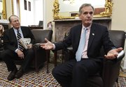 Sen. Judd Gregg, R-N.H., right, accompanied by Sen. Lamar Alexander, R-Tenn., gestures during a health care news conference Thursday on Capitol Hill in Washington.