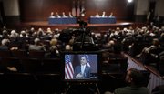 President Barack Obama is seen in a television monitor Saturday during his visit to Capitol Hill to meet with House Democrats in Washington.