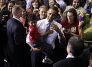 President Barack Obama picks up 4-year-old Barack Anthony Stroud after speaking about health care reform, Thursday at the University of Iowa in Iowa City.