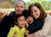 Bethany and Kevin Durkin hold their daughters Olivia, 7, left, and Lucy, 5, March 13 in their in Katonah, N.Y,. home. The Durkins are part of a growing number of parents who have adopted special-needs children from China. Olivia had a weak, underused right arm when she was adopted in 2004, while Lucy had a cleft palate that was repaired through surgery soon after her adoption in November 2007.