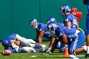 Defensive line coach Buddy Wyatt demonstrates proper fumble recovery technique during spring practice on Sunday, March 28, 2010.
