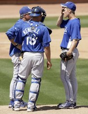 Kansas City Royals pitcher Zack Greinke, right, wipes his brow as he confers with pitching coach Bob McClure, left, and catcher Jason Kendall on Wednesday in Peoria, Ariz. The Royals will start the season without much depth behind the 2009 Cy Young winner. K.C. recently was forced to put No. 2 starter Gil Meche on the disabled list because of shoulder stiffness.